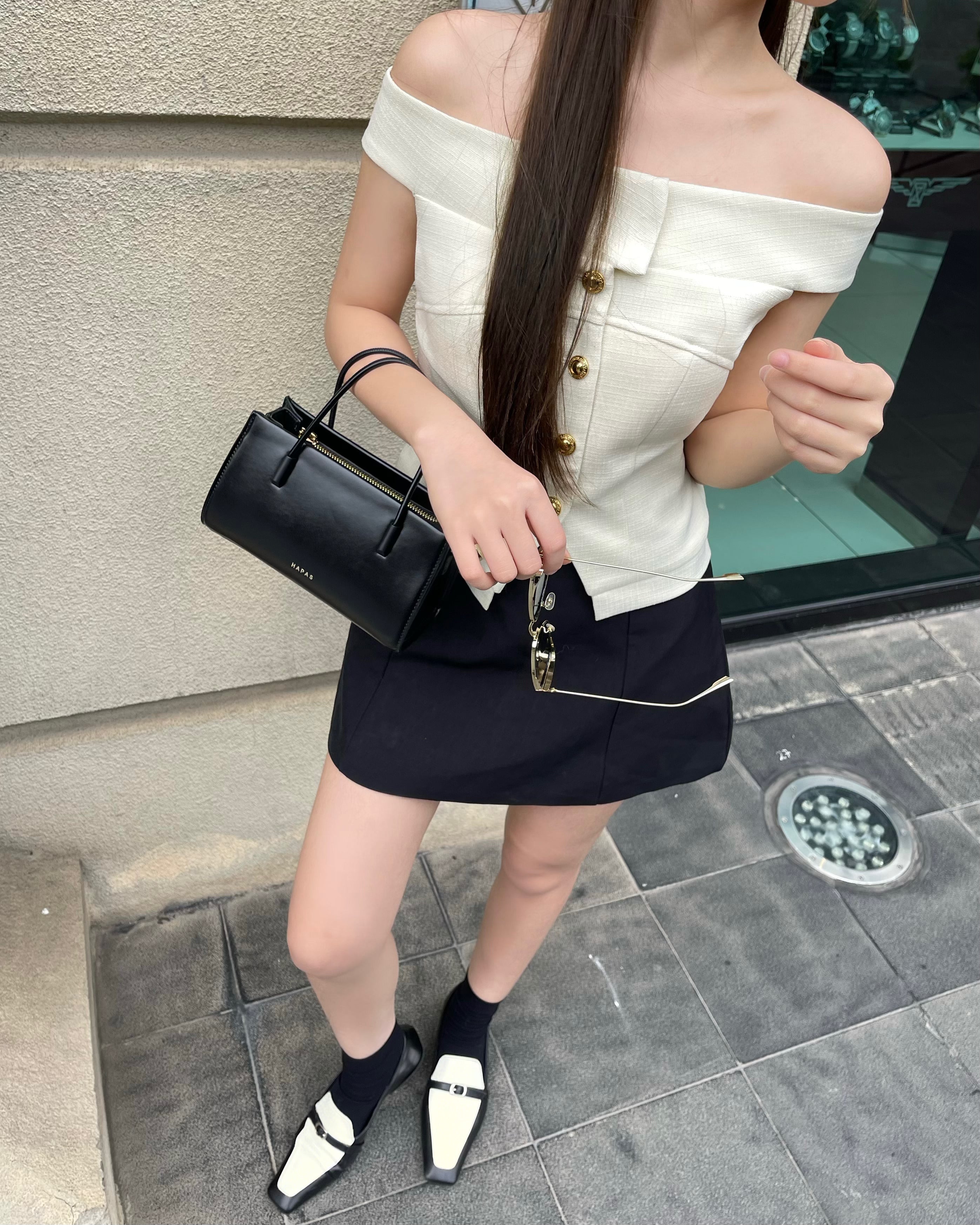 Chic-woman-holding-Hapas-minimalist-handbag-by-the-handle